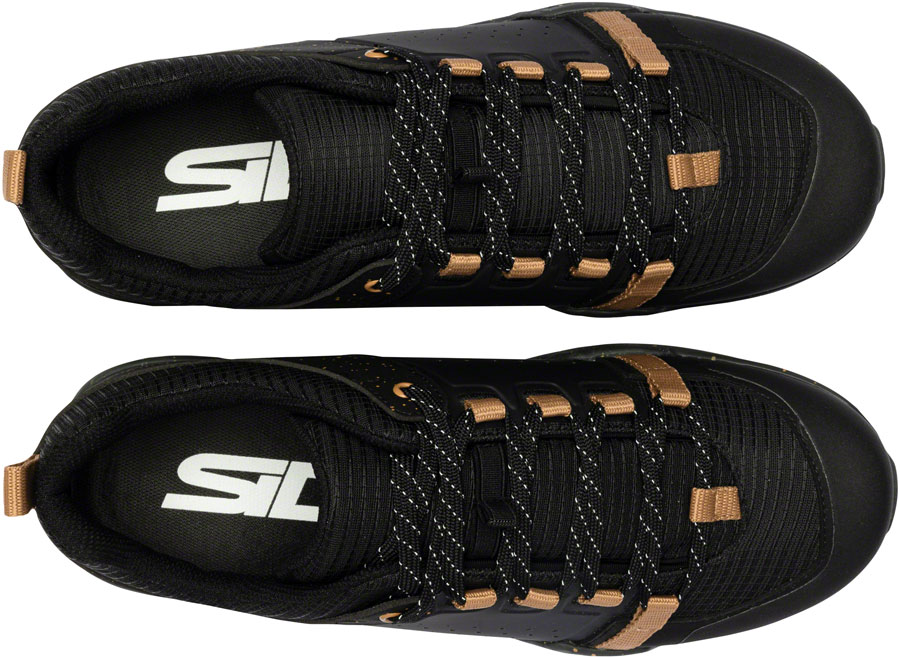 Black athletic shoes with brown accents and a visible brand logo on a white background