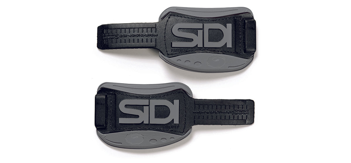 Two black Sidi shoe straps on a white background