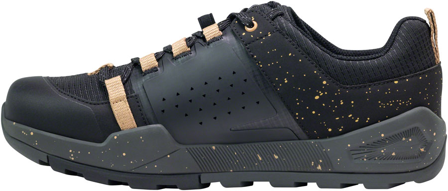 Black and gold athletic shoe with speckled pattern on a white background