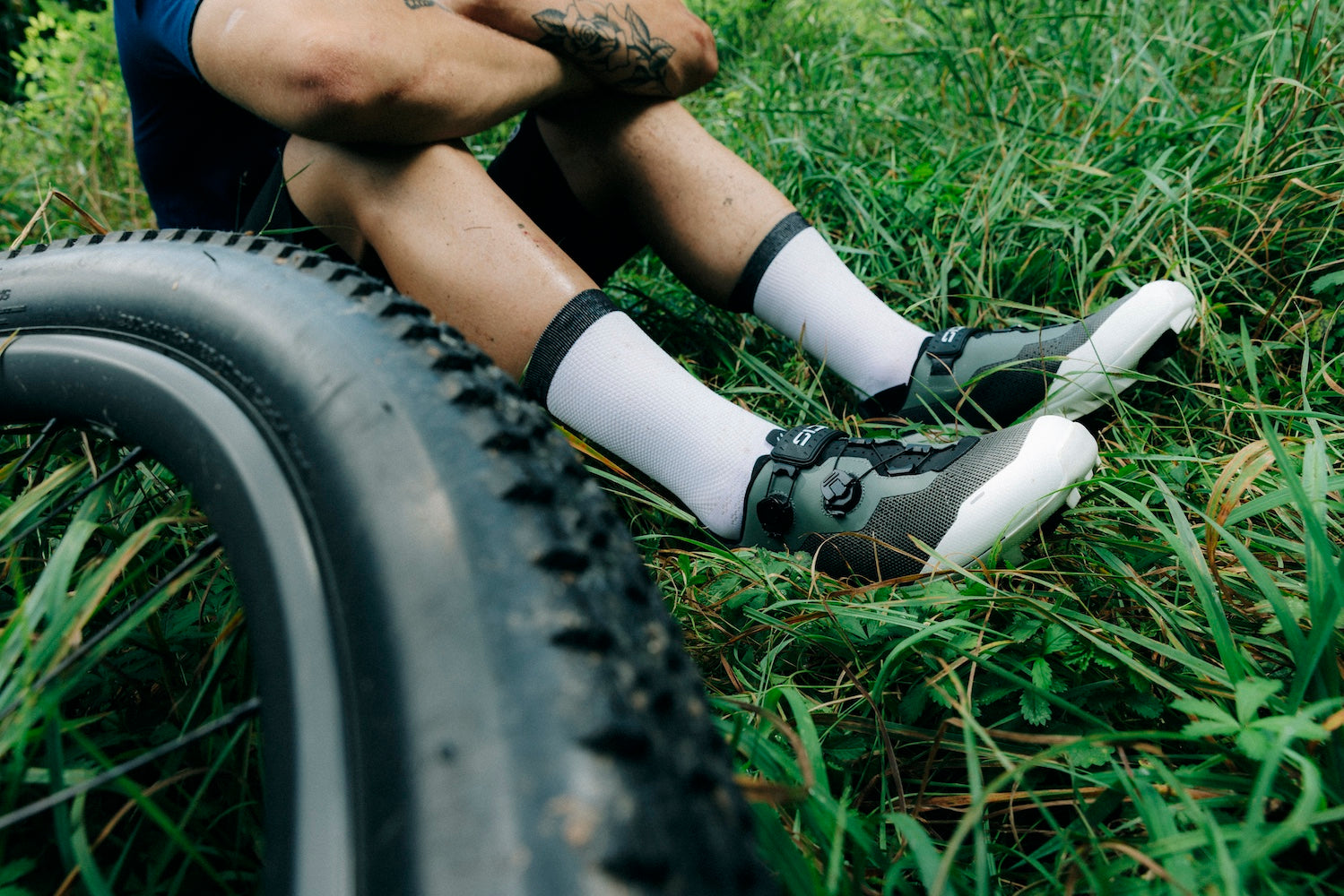 Cyclist sits in grass while wearing SIDI Dominator X mountain cycling shoe