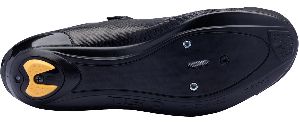 Black cycling shoe sole with yellow cleat area on a white background
