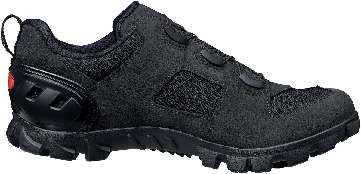 Black shoe from the side with red accent on the heal and mesh fabric