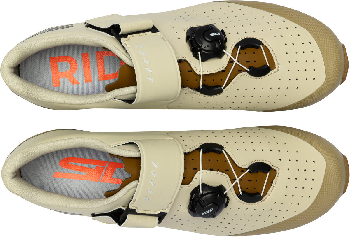 Pair of beige cycling shoes with brand logos on a white background