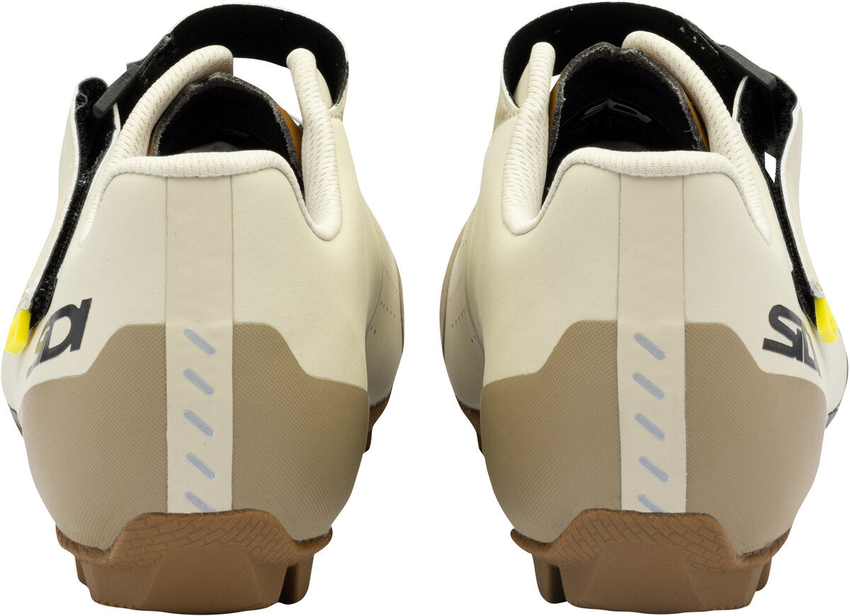 Pair of beige cycling shoes with brown soles on a white background